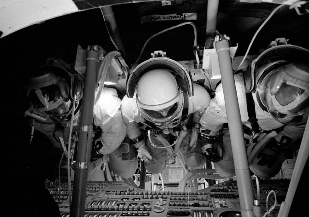 Three astronauts inside the Command Module Simulator in Building 5 during an Apollo Simulation.